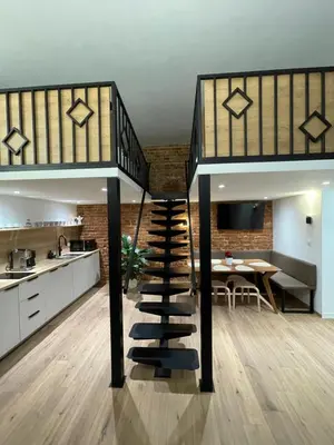 a staircase leading up to a kitchen and dining room at Kurkowa GamaHome Cozy Apartments in Kraków