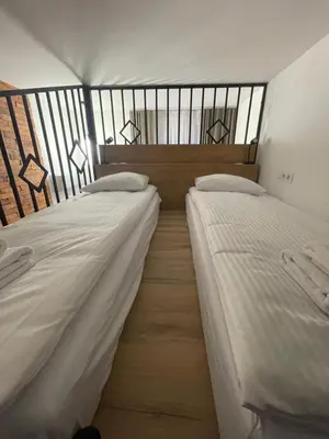two twin beds in a room with a window at Kurkowa GamaHome Cozy Apartments in Kraków