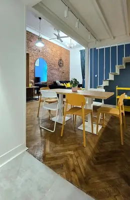 a dining room with a table and chairs and stairs at Kurkowa GamaHome Cozy Apartments in Kraków