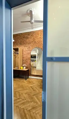 a room with a brick wall and a ceiling fan at Kurkowa GamaHome Cozy Apartments in Kraków