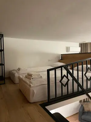 two beds sitting in a room with a staircase at Kurkowa GamaHome Cozy Apartments in Kraków