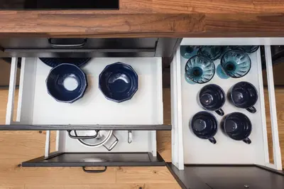 a cabinet filled with black and white plates and bowls at City of the Kings - Botany Bay Apartment in Kraków
