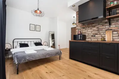 a bedroom with a bed and a brick wall at City of the Kings - Botany Bay Apartment in Kraków