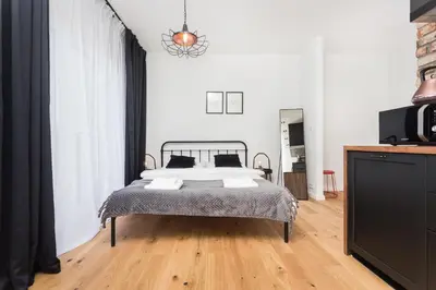 a bedroom with a bed and a television in it at City of the Kings - Botany Bay Apartment in Kraków