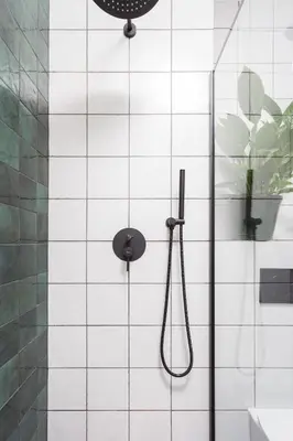 a shower in a bathroom with white tiled walls at City of the Kings - Botany Bay Apartment in Kraków