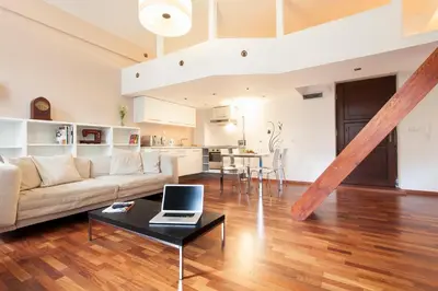 a living room with a couch and a table with a laptop at DaVinci Radziwiłłowska Apartments in Kraków