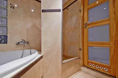 a bathroom with a bath tub and a window at DaVinci Radziwiłłowska Apartments in Kraków