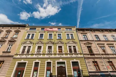 a yellow building with many windows and a blue sky at DaVinci Radziwiłłowska Apartments in Kraków