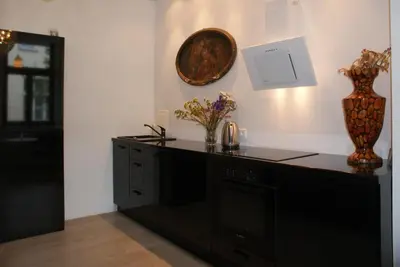 a kitchen with a black counter and a clock on the wall at DaVinci Radziwiłłowska Apartments in Kraków