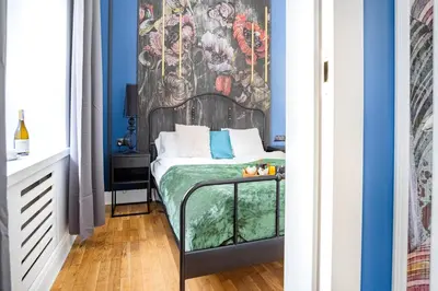 a bedroom with a bed with a painting on the wall at AT Krakow Apartments in Kraków
