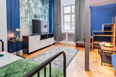 a living room with a bed and a tv at AT Krakow Apartments in Kraków