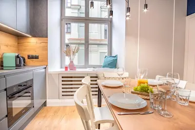 a kitchen with a table and chairs and a dining room at AT Krakow Apartments in Kraków