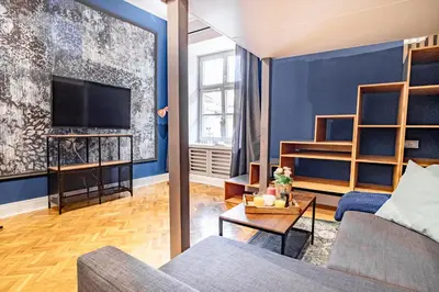 a living room with a couch and a tv at AT Krakow Apartments in Kraków