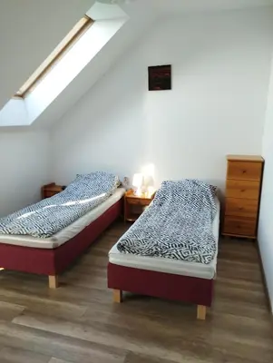 two twin beds in a room with a attic at Noclegi Pod Dębem in Skawina