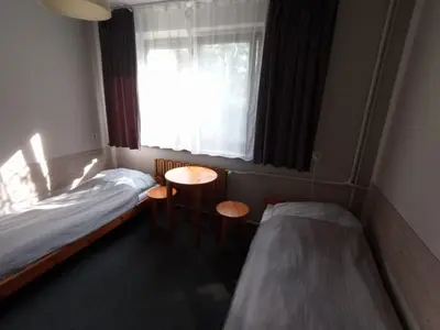a small room with two beds and a window at Noclegi Pod Dębem in Skawina