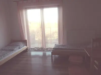 a room with two beds and a large window at Noclegi Pod Dębem in Skawina