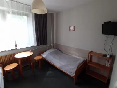 a bedroom with a bed and a table and chairs at Noclegi Pod Dębem in Skawina