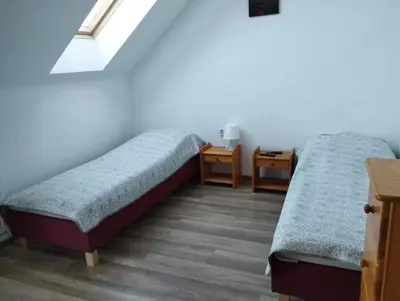 a room with two beds and a table at Noclegi Pod Dębem in Skawina