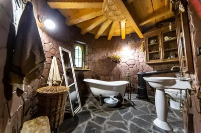 a stone bathroom with a tub and a sink at Przystań 545 in Rożnów
