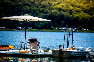 a couple of boats on a lake with an umbrella at Przystań 545 in Rożnów