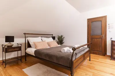 a bedroom with a bed and a table with a lamp at Apartamenty w Dworku Cheval in Kraków
