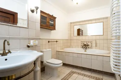 a bathroom with a sink and a tub and a toilet at Apartamenty w Dworku Cheval in Kraków