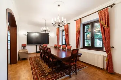 a dining room with a table and chairs and a flat screen tv at Apartamenty w Dworku Cheval in Kraków