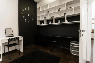 a black and white room with a desk and a clock at Vintage Tomasza Apartment in Kraków