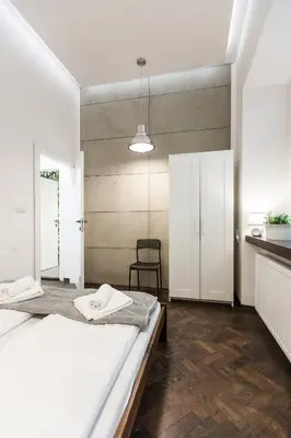 a bedroom with two beds and a chair at Vintage Tomasza Apartment in Kraków