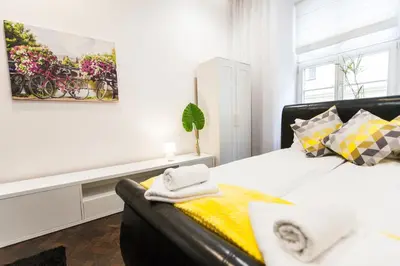 a white bedroom with a bed and a couch at Vintage Tomasza Apartment in Kraków