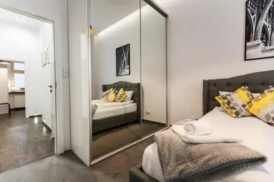 a bedroom with a mirror next to a bed at Vintage Tomasza Apartment in Kraków