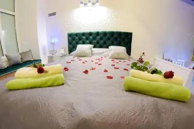 a bedroom with a large bed with roses on it at Apartment Jacuzzi in Kraków