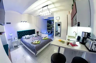 a small room with a bed and a kitchen at Apartment Jacuzzi in Kraków