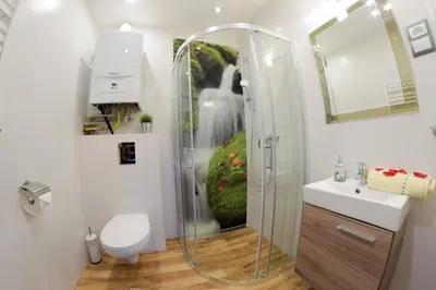 a bathroom with a shower and a toilet and a sink at Apartment Jacuzzi in Kraków