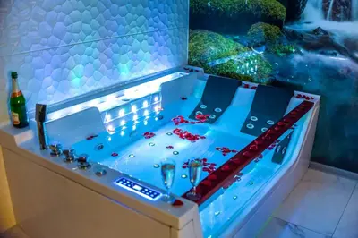 a drink table with a bottle of wine and glasses at Apartment Jacuzzi in Kraków