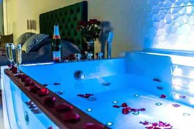a bathroom with a tub with a bottle of champagne at Apartment Jacuzzi in Kraków