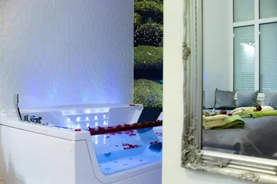 a mirror next to a bed in a room at Apartment Jacuzzi in Kraków