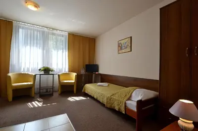 a hotel room with a bed and a table and chairs at Arka Kraków in Kraków