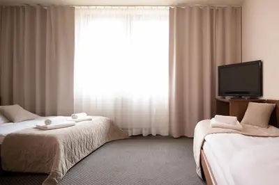 a hotel room with two beds and a flat screen tv at Arka Kraków in Kraków