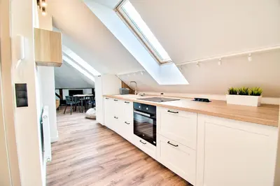 a kitchen with white cabinets and a skylight at City Life Apartments Kraków in Kraków