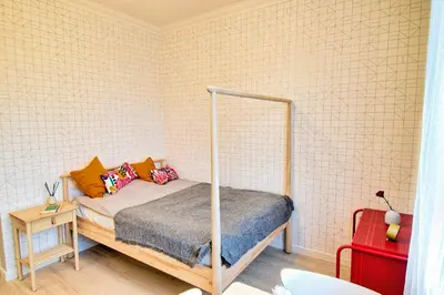 a bedroom with a bed and a red suitcase at City Life Apartments Kraków in Kraków