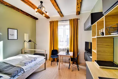 a bedroom with a bed and a desk and a table at City Life Apartments Kraków in Kraków
