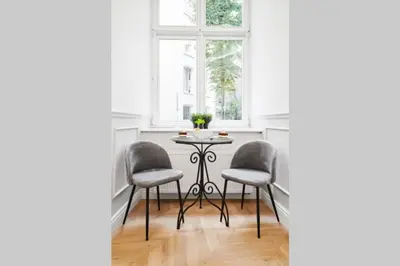 a table in a room with two chairs and a window at HOUSEHOST Apartment I: Studencka Street in Kraków