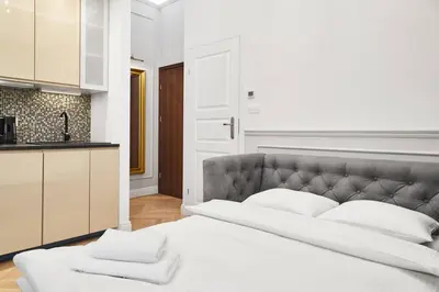 a bedroom with a large white bed with white pillows at HOUSEHOST Apartment I: Studencka Street in Kraków