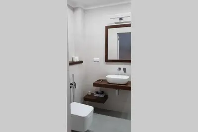 a bathroom with a sink and a toilet and a mirror at BOUTIQUE 109 - old city, luxury apt. with a garage in Kraków