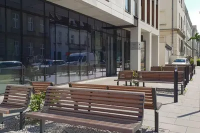 a row of wooden benches sitting on a sidewalk at BOUTIQUE 109 - old city, luxury apt. with a garage in Kraków