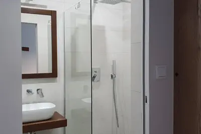 a bathroom with a glass shower and a sink at BOUTIQUE 109 - old city, luxury apt. with a garage in Kraków