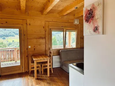 a kitchen with a table and a couch and windows at Domki góralskie na Podhalu Zakopane in Tokarnia