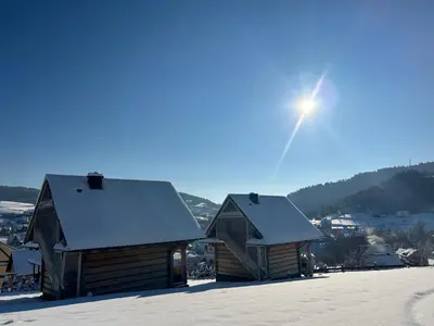 two wooden cabins with snow on the roofs at Domki góralskie na Podhalu Zakopane in Tokarnia