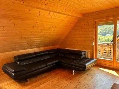 a leather couch in a room with a window at Domki góralskie na Podhalu Zakopane in Tokarnia